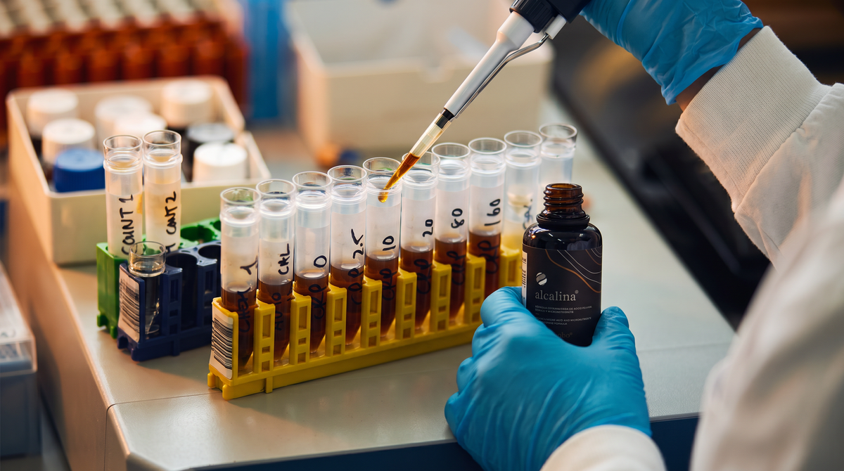 Vial de laboratorio con una solución mineral dorada.