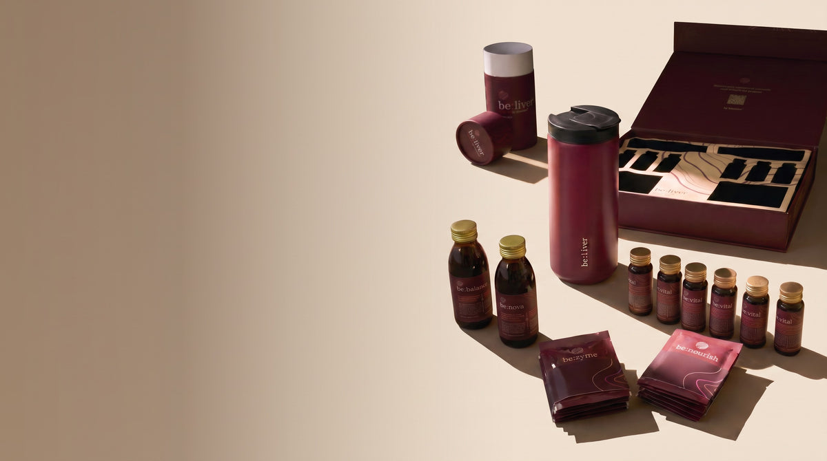 El kit be:liver con su vaso, sus botellas y sus sobres sobre una mesa con luz de tarde