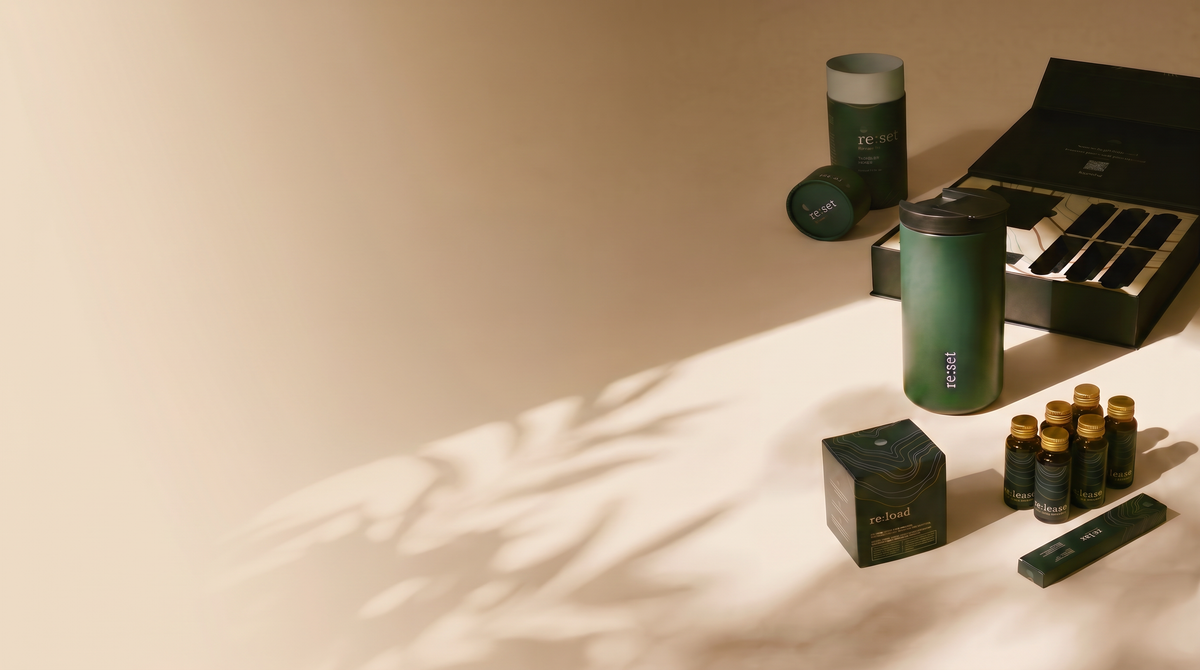 Kit re:set con botellas y sobres junto a su caja, sobre fondo crema con una sombra alargada.