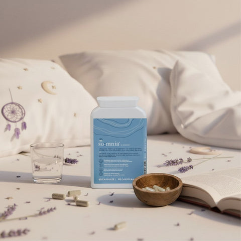 Bionobo so:mnia sleep aid capsules in a white bottle with blue wave design, next to a glass of water and a bowl of capsules.
