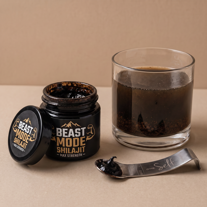 Resina de shilajit convencional oscura junto a un vaso de agua turbia con sedimento visible.
